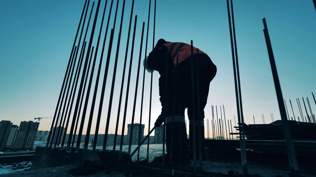 詳情圖-建筑工地的建筑工人。建筑工地和一名建筑工人正在打碎混凝土