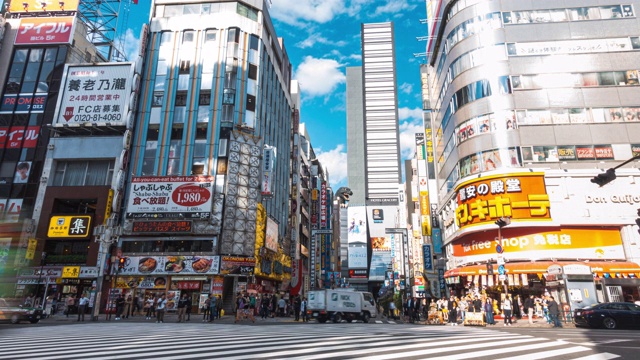 在日本东京新宿区哥斯拉路购物街上行走的行人，4K延时:车流和人群