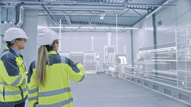 两位工程师在工厂车间用AR创建三维模型CNC机械生产线。工业4.0图形可视化工厂。弧。VFX特殊视觉效果