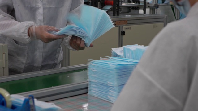 详情图-车间里成堆的医用口罩。生产医用服装。Covid19