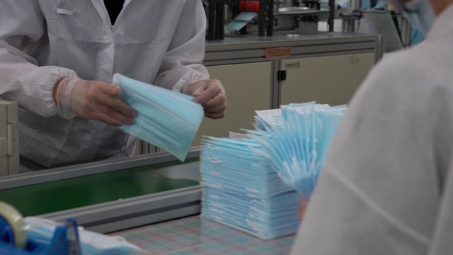 详情图-车间里成堆的医用口罩。生产医用服装。Covid19