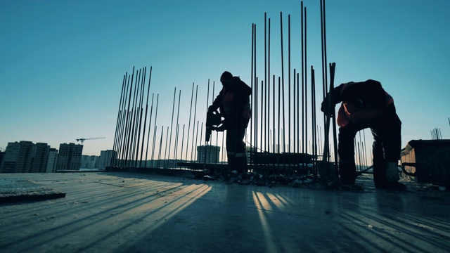 工人们正在建筑工地上铲去碎混凝土