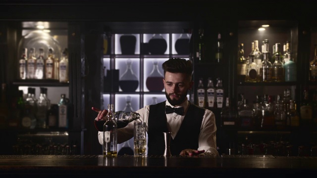 酒保正在把一瓶酒倒进杯子里。4 k