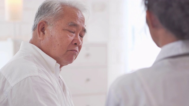 詳情圖-亞裔老年男子聽著年輕的黑人女護士醫(yī)生在家給他年長的男性病人咨詢。采購產(chǎn)品醫(yī)療，護理，護理，退休，志愿者，慈善，教育，養(yǎng)老院，在家照顧者，醫(yī)藥和衛(wèi)生保健
