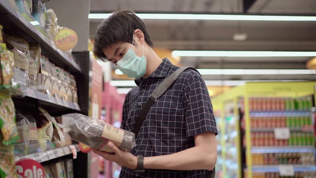 詳情圖-年輕男子戴著防護(hù)口罩在超市購(gòu)物