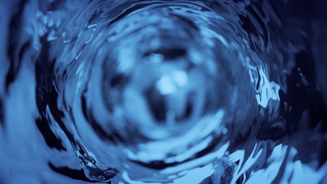 杯子里的水是慢动作的。抽象的蓝色水背景。无缝循环3d渲染