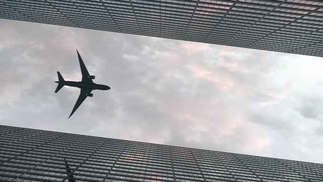 飞机在美丽的天空下飞过办公大楼