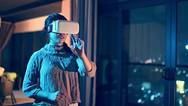詳情圖-一位亞洲華裔少女戴上VR眼鏡，在客廳體驗(yàn)3D虛擬游戲體驗(yàn)