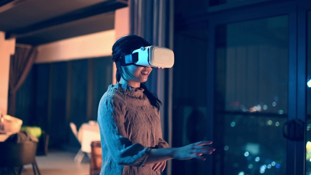 詳情圖-一位亞洲華裔少女戴上VR眼鏡，在客廳體驗(yàn)3D虛擬游戲體驗(yàn)