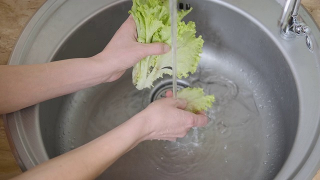 Womаn洗生菜。