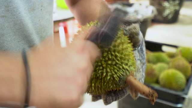 水果小贩在榴莲店开新鲜榴莲
