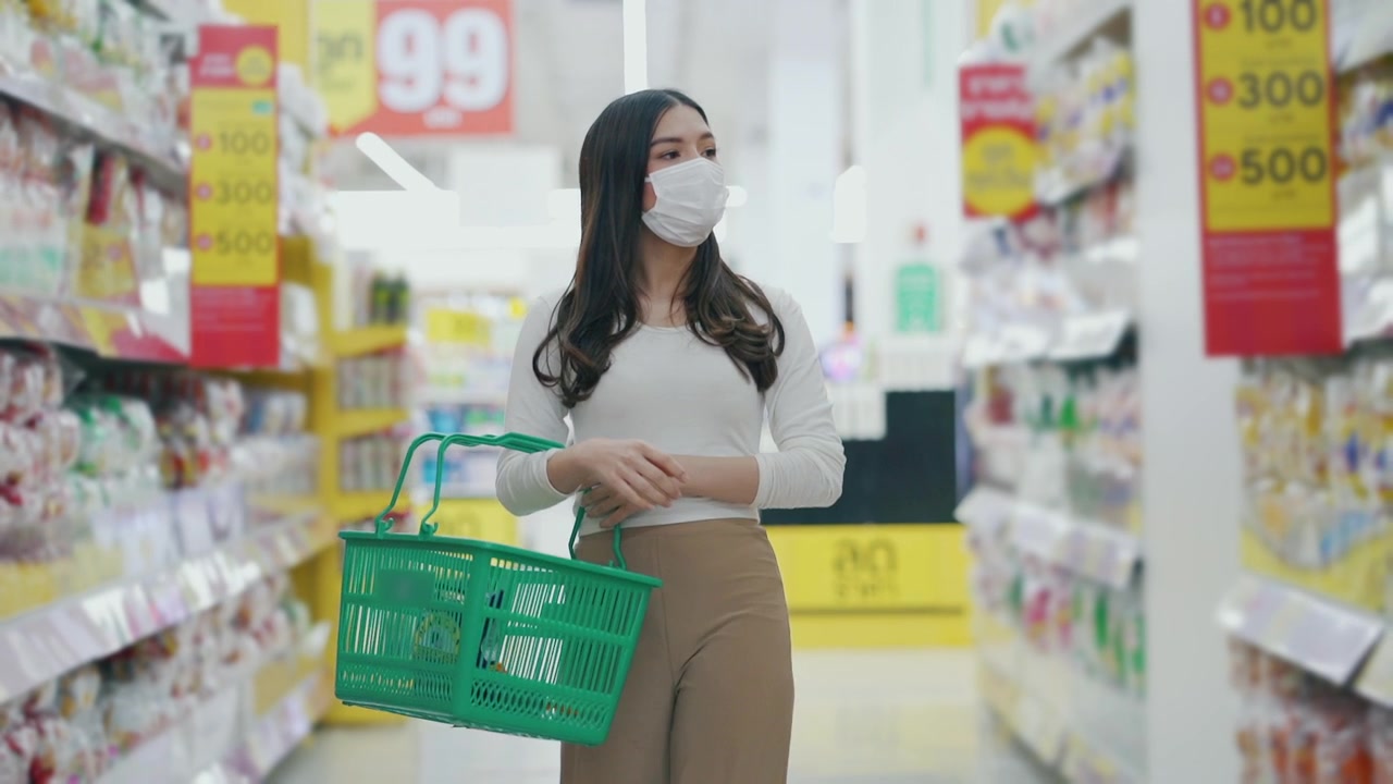 詳情圖-戴著口罩的女人在超市購物和檢查食品貨架