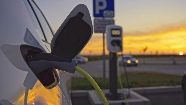 黃昏時分，在停車場的充電站為汽車充電