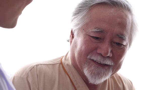 特写一位老年病人在医院向他的医生展示