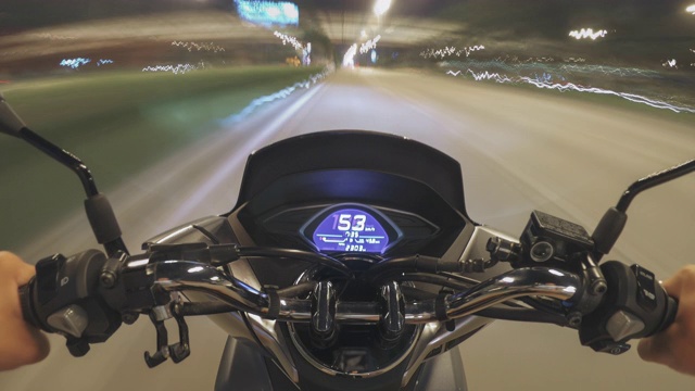 那个骑摩托车的人在夜间的公路上骑着摩托车旅行