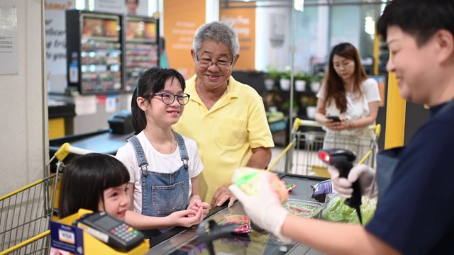 詳情圖-一名亞洲華人老人周末和他的孫女一起結(jié)帳和買雜貨