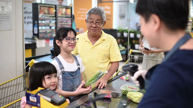 詳情圖-一名亞洲華人老人周末和他的孫女一起結(jié)帳和買雜貨