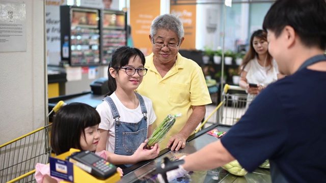 詳情圖-一名亞洲華人老人周末和他的孫女一起結(jié)帳和買雜貨