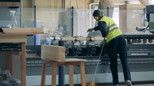 详情图-工厂工人正在向工业机器上喷洒化学药品