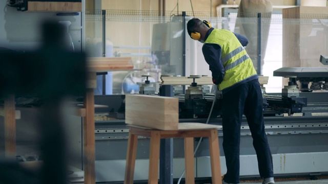 详情图-工厂工人正在向工业机器上喷洒化学药品