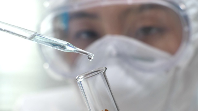 在实验室里，科学家将液体从移液管转移到试管中