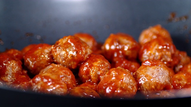 準(zhǔn)備好的肉丸在番茄醬鍋中慢慢旋轉(zhuǎn)。