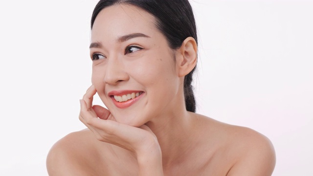详情图-微笑的亚洲妇女肖像应用面霜与白色的背景。