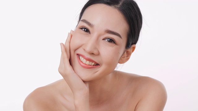 详情图-微笑的亚洲妇女肖像应用面霜与白色的背景。