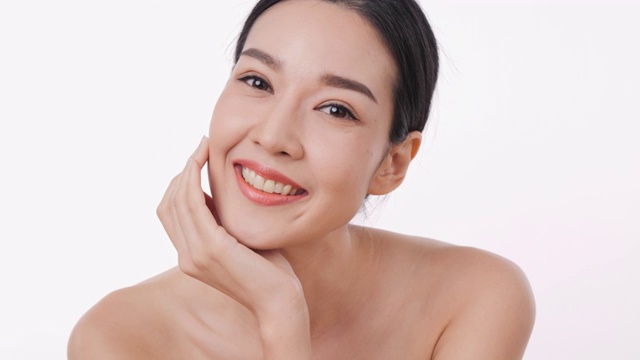 详情图-微笑的亚洲妇女肖像应用面霜与白色的背景。