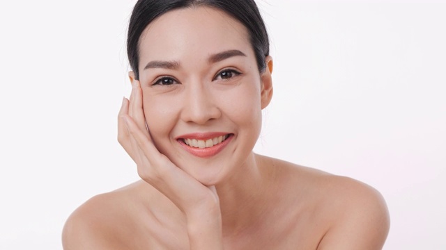 详情图-微笑的亚洲妇女肖像应用面霜与白色的背景。