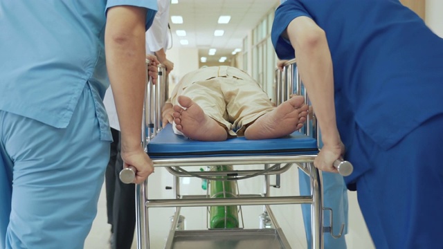 医护人员将急诊病人从医院走廊转移到急诊室的后视图
