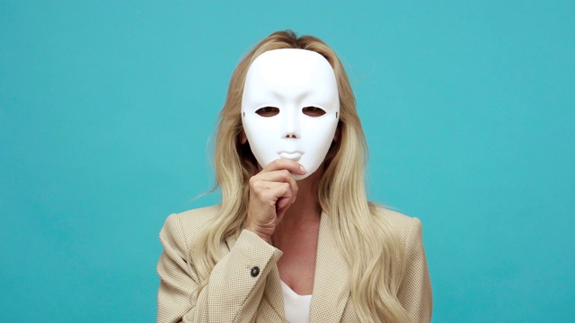 详情图-自信的金发中年妇女在商务风格夹克脱下面具显示不同的情绪，表里不一，虚伪