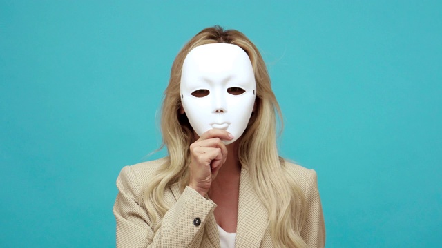 详情图-自信的金发中年妇女在商务风格夹克脱下面具显示不同的情绪，表里不一，虚伪