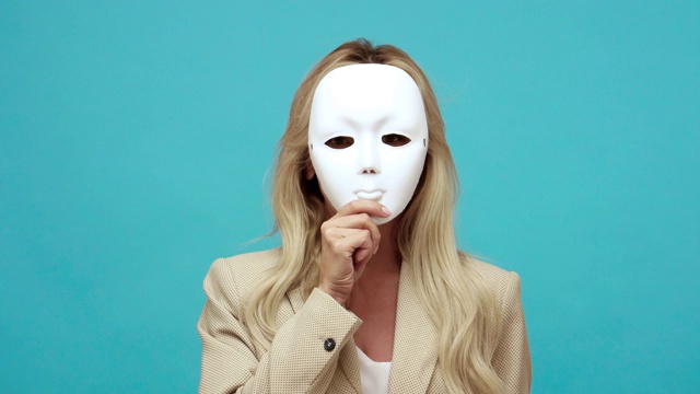 详情图-自信的金发中年妇女在商务风格夹克脱下面具显示不同的情绪，表里不一，虚伪