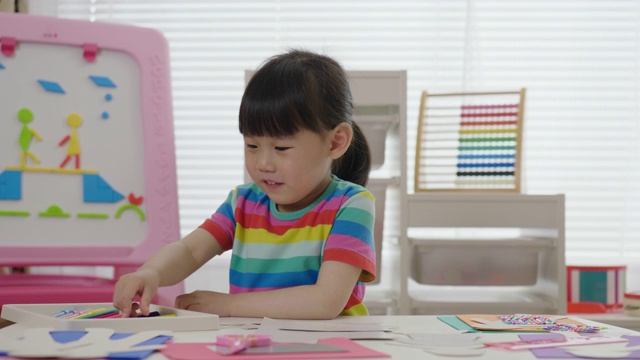 年轻女孩手工制作纸工艺品供家庭教育