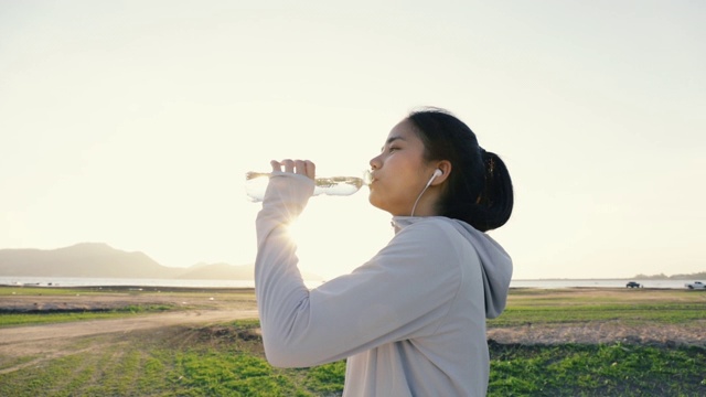詳情圖-年輕的亞洲女人跑步喝水后在戶外的山。