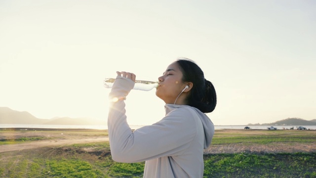 詳情圖-年輕的亞洲女人跑步喝水后在戶外的山。