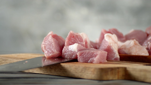 一片片生猪肉落在砧板上。