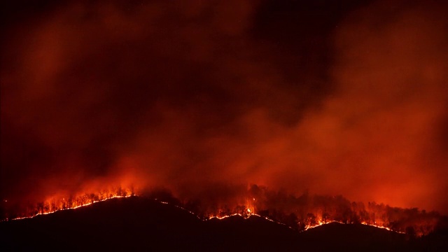 火的时间流逝森林野火在夜间的山脉与副本空间在天空