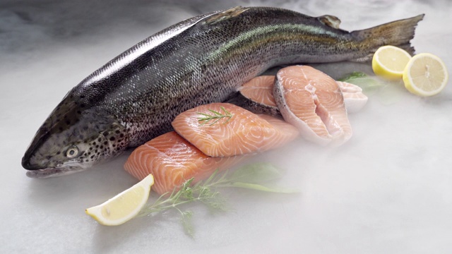 詳情圖-4K超高清:鮭魚及其魚片在黑色背景和冰凍的冰煙。新鮮豪華海鮮和菜單食譜零售市場概念。