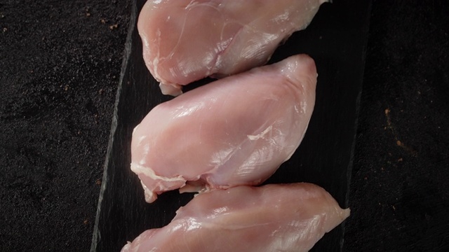 在一块石板上，生鸡肉片旋转着。
