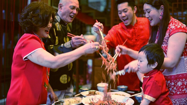 亚洲华人家庭春节团圆饭吃传统菜肴生鱼刘生