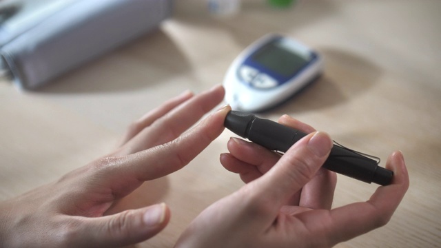 近距离观察手部女性糖尿病患者的血糖水平是指血测试，日常糖尿病护理