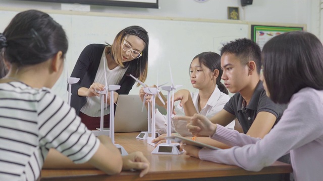 教育的概念。老师饶有兴趣地给孩子们讲解风力涡轮机的操作。