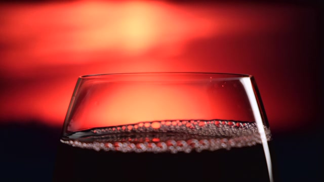 详情图-在美丽的落日背景下，红酒从瓶子中倒入玻璃杯。晚上。夏天。日落。在大自然中庆祝生日。副本的空间。葡萄酒和晚餐，晚餐的概念
