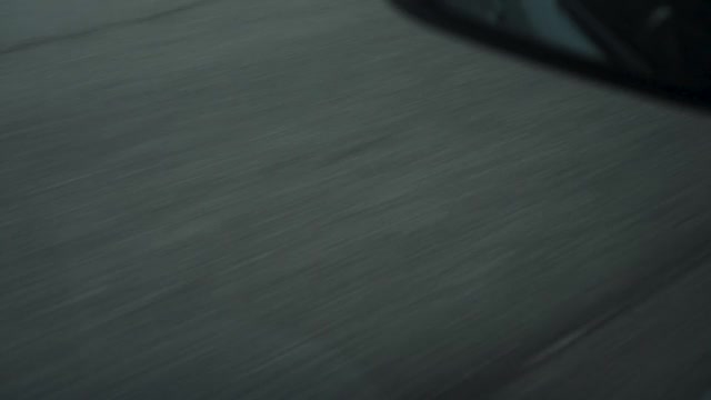 高速公路上行驶的汽车，沥青路面。可穿戴相机拍摄显示磨损和不平的柏油路面从一辆行驶的车辆