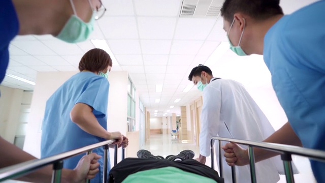 詳情圖-4K超高清縮小視角低角度拍攝:病人在醫(yī)院輪床擔(dān)架床上被醫(yī)療團(tuán)隊運(yùn)送到醫(yī)院走廊。