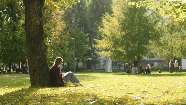 一個(gè)年輕女子在公園里看書