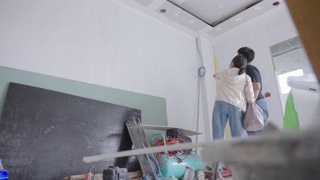 亚洲女建筑师在工地与建筑承包商讨论。