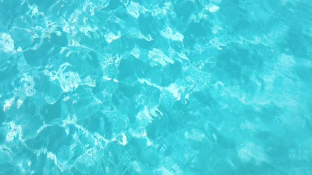 在阳光明媚的日子里，游泳池里亮晶晶的水